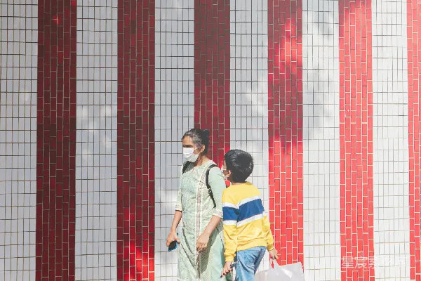 高清摄影 男人和女人在白天亲吻，背景是红白相间的墙。