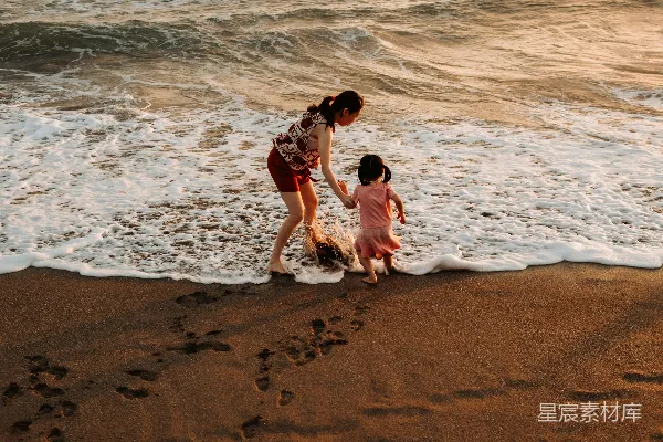 高清摄影 母子在夕阳下漫步海滩