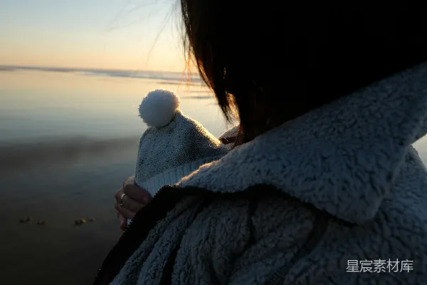 高清摄影 一个抱着孩子的女人站在海滩上。