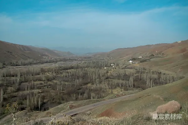 高清摄影 一幅山间谷地的美景，背景中有树木和山脉。