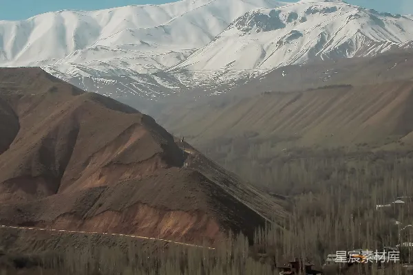 高清摄影 一座雪山连绵，前面有一个村庄。