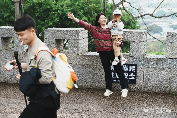 高清摄影 一家人正沿着石阶向上走，可以看到城市景色。