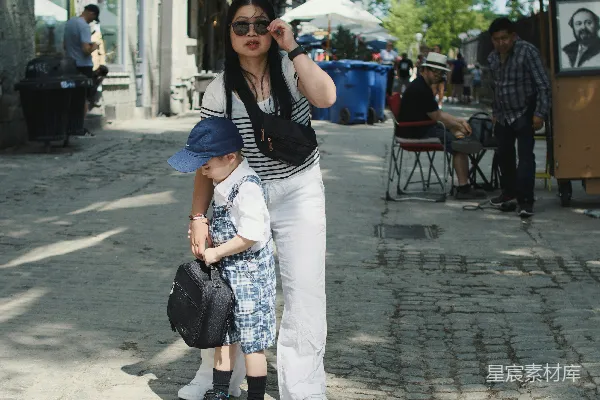 高清摄影 女人和孩子走在鹅卵石街道上。