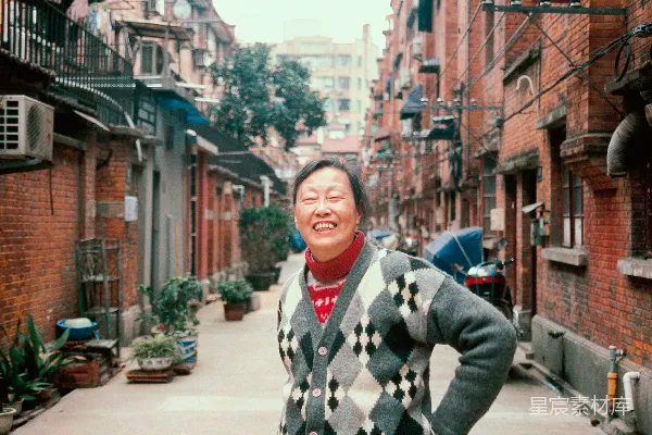 高清摄影 穿黑白相间的毛衣的男人站在人行道上，时间是白天。