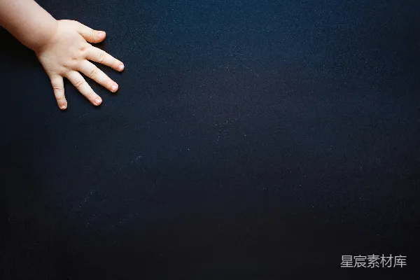 婴儿的手放在黑色表面之上