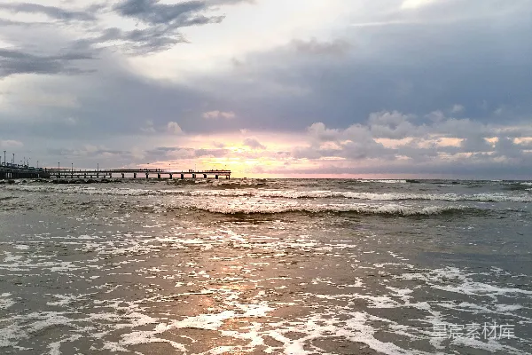 灰海观涛，白灰阴天中日落海滩码头处