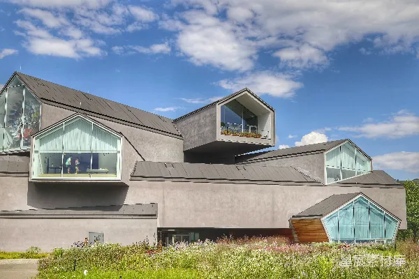 高清摄影 一幢有窗户的建筑前面有一个草地。