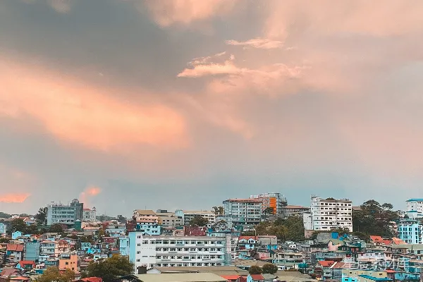 高清摄影 城市中有高耸的建筑，在橙色和灰色的多云天空下。