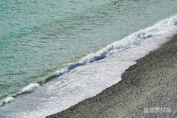 温柔的波浪轻抚着卵石海滩。