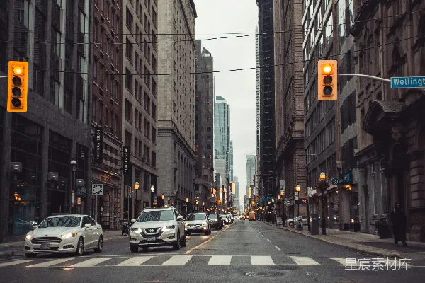 高清摄影 白天，高楼大厦之间路边停着的车辆。
