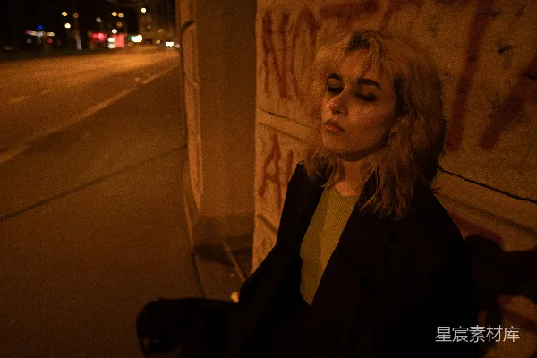 高清摄影 一个女人站在涂鸦墙旁边。