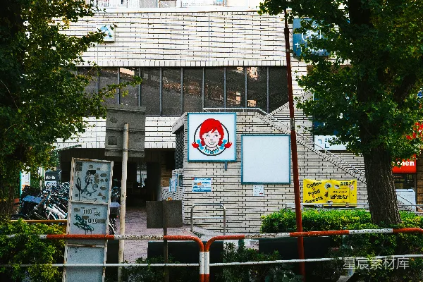 高清摄影 一座砖砌的建筑，前面有树和一个标牌。