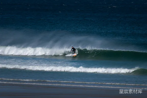一个男人骑在冲浪板上 surfing atop a wave