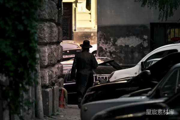 高清摄影 穿着黑色夹克和棕色帽子的男人站在白天的黑色汽车旁边。