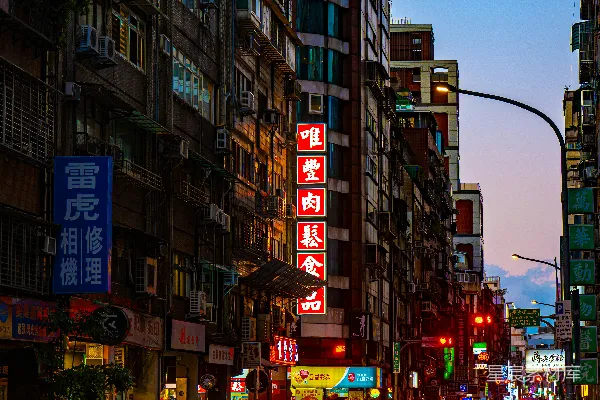 繁忙的街道上车水马龙，霓虹灯在傍晚时分闪烁。