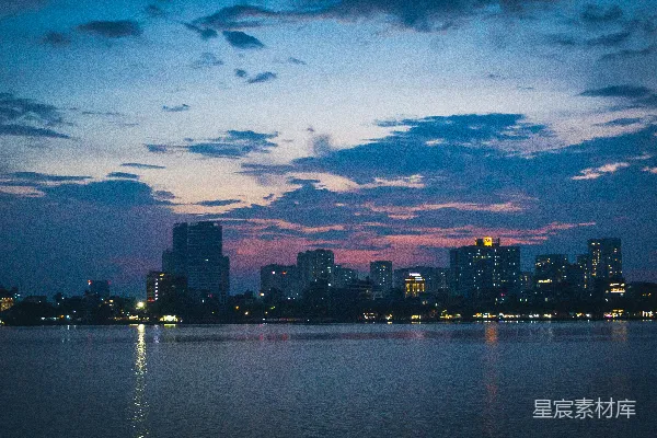 高清摄影 一片广阔的水域，背景中有座城市。