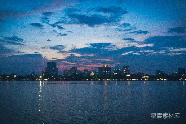 高清摄影 一片广阔的水域，背景中有座城市。