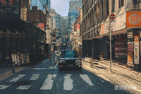 高清摄影 一辆汽车行驶在高楼大厦旁边的街道上。