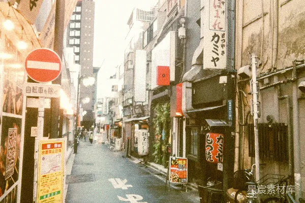 高清摄影 一条狭窄的城市街道，两旁排列着建筑物和标志牌。