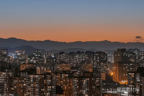 高清摄影 夜晚的城市景色，背景是山脉。