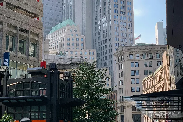 高清摄影 一群人沿着街边高大的建筑物行走。