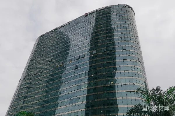 前面有一座带树木的高大建筑物。