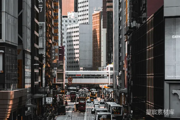 高清摄影 在白天，红白相间的公交车行驶在高楼大厦之间的道路上。