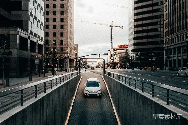 高清摄影 白天建筑物之间的道路上行驶的汽车