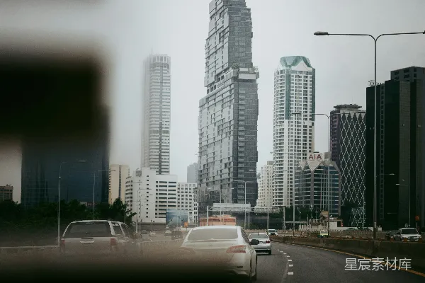 高清摄影 一辆汽车在高楼大厦旁的街道上行驶