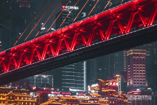 高清摄影 一座红色的桥横跨河流，背景中有个城市。