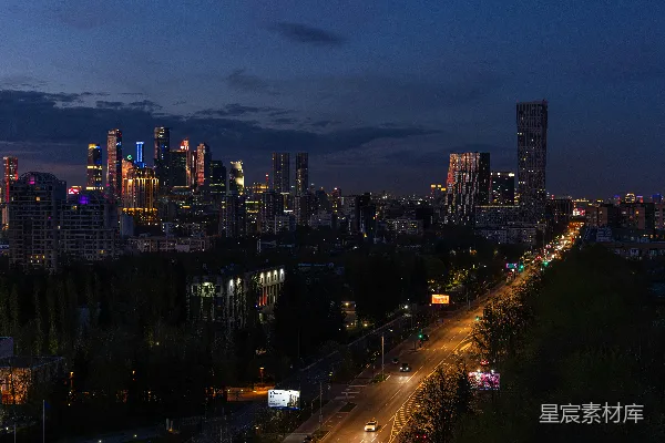 高清摄影 灯火辉煌的城市夜景，高耸的摩天大楼被照亮，道路也灯火通明。