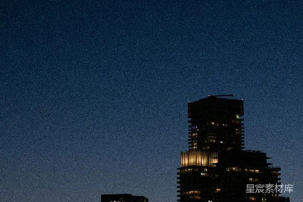 高清摄影 夜晚的城市景色，月亮高悬在天空中。