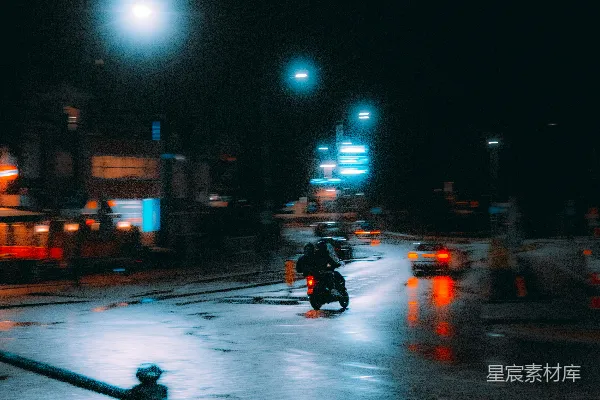 夜晚一个人骑摩托车在街上行驶