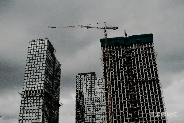 高清摄影 两栋高大的建筑在多云的天空下，旁边有一台起重机。