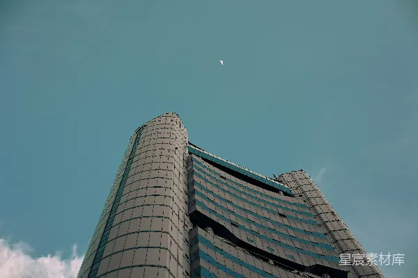 高清摄影 一座高楼，天空中挂着一轮弯月。