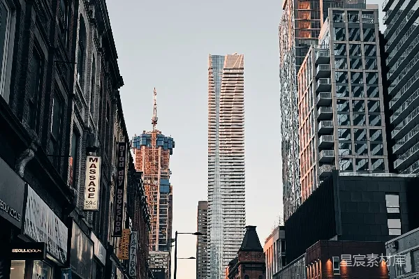 高清摄影 一群人在高楼大厦旁的街道上骑自行车。