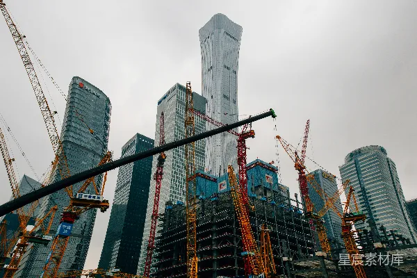 高清摄影 一群高大的起重机站在一幢高楼前面。