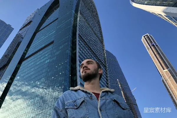 高清摄影 低角度拍摄站在高楼玻璃建筑旁的男人