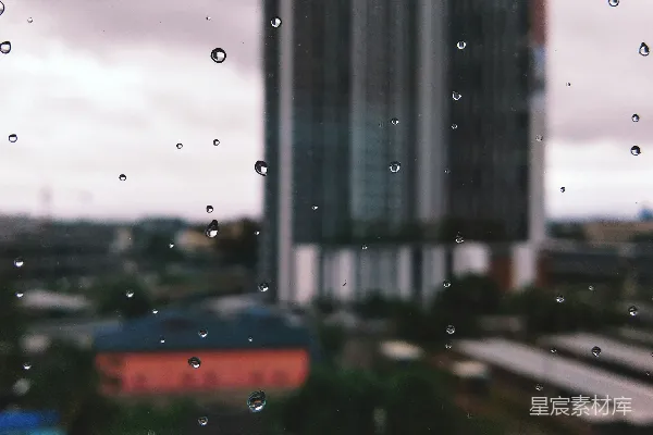 高清摄影 一扇湿漉漉的窗户透过它看到一栋建筑物。