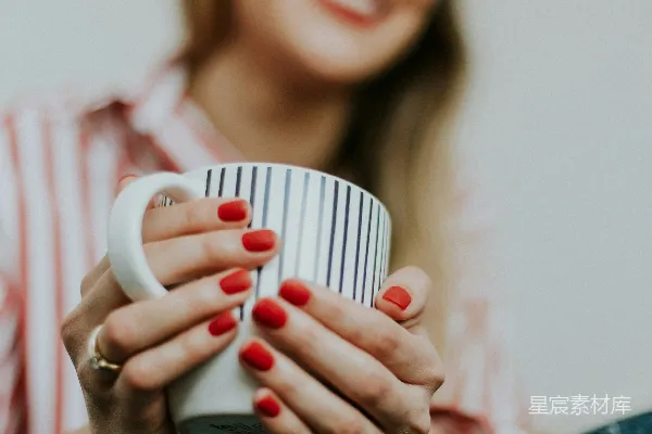 持白黑陶瓷茶杯的女士