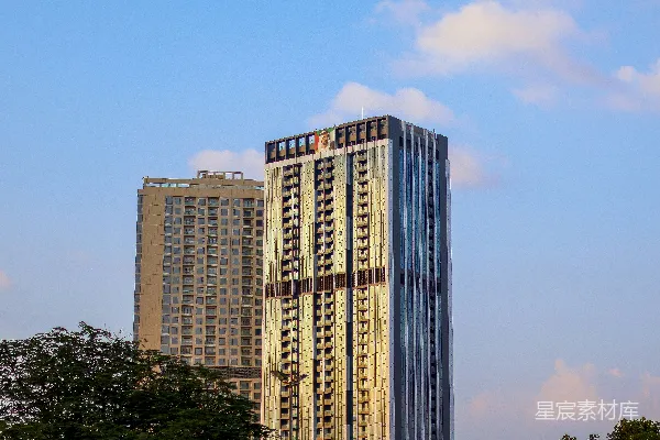 高清摄影 一座高楼坐落在郁郁葱葱的绿色公园旁边