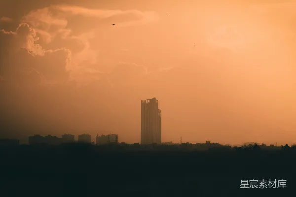 高清摄影 一座高耸的建筑物在多云的天空下凌驾于城市之上。