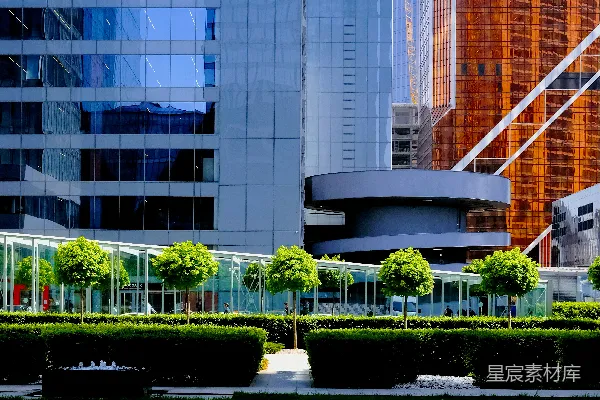 高清摄影 白天，白色混凝土建筑旁边有绿色树木。