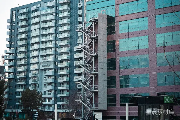 高清摄影 一座高楼，有许多窗户，旁边是一个停车场。