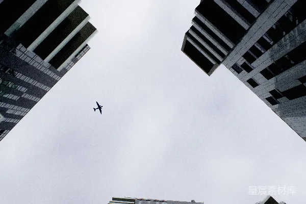高清摄影 低角度拍摄建筑物下的飞行飞机