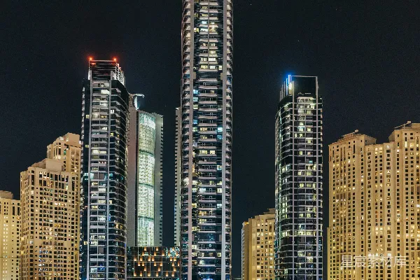 高清摄影 三栋灯火通明的高层建筑靠近水体。