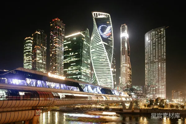 高清摄影 夜晚的城市景象，高楼林立，一辆火车驶过。