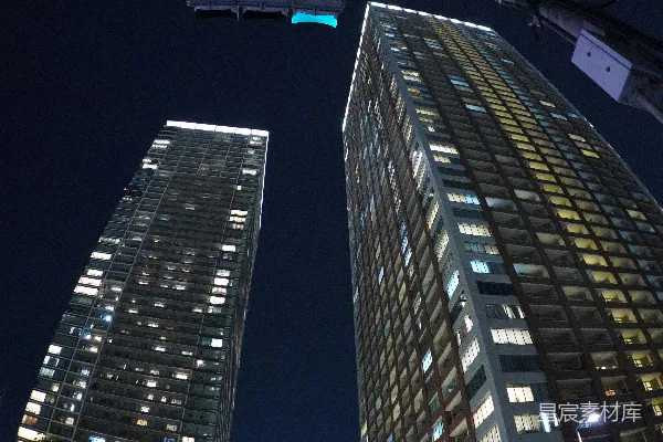 高清摄影 在夜晚，高楼大厦之间有车辆行驶。