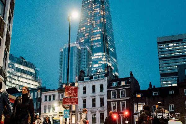 高清摄影 一群人正穿过一栋高楼前的街道。
