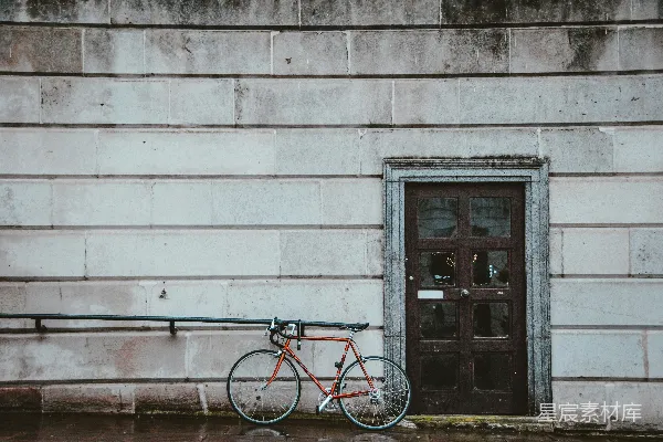 高清摄影 红色城市自行车停在灰色混凝土墙旁边